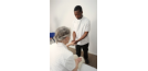 Male osteopath treating female patient's hand