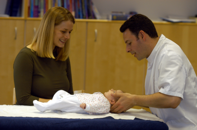 Male osteopath with child and mother