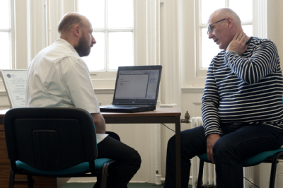 Osteopath and middle-aged man consultation