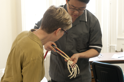 Osteopath with woman - skeleton arm