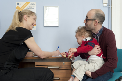 Female osteopath with parent of toddler