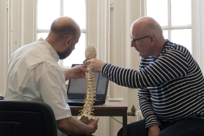 Male osteopath with middle-aged man - spine