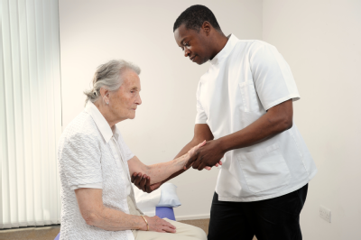 Osteopath and elderly woman - arms