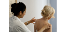 Female osteopath and elderly lady