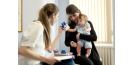 Female osteopath with mother and baby