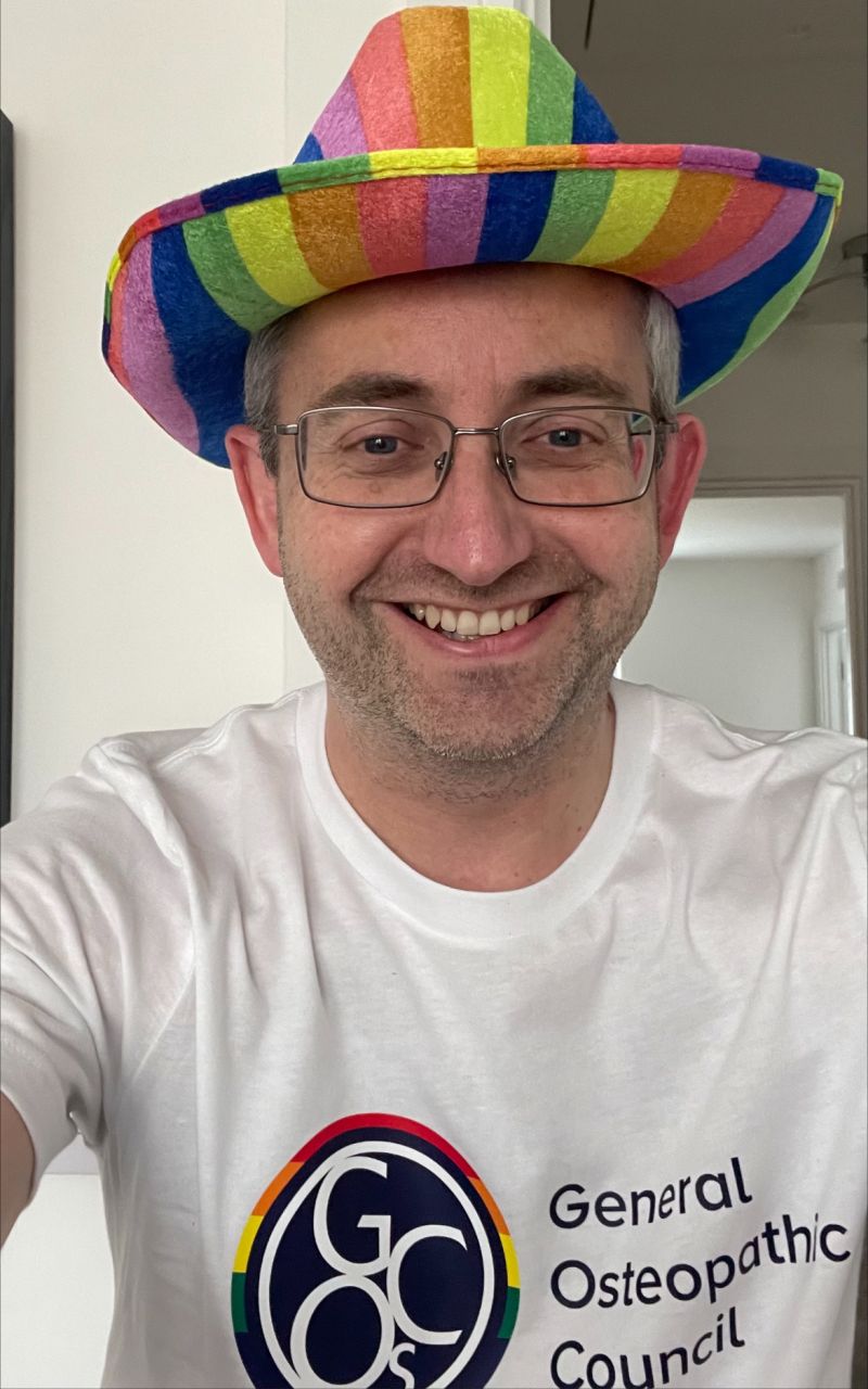 A selfie of Matthew Redford, GOsC Chief Executive and Registrar in a rainbow cowboy hat and GOsC Pride tshirt