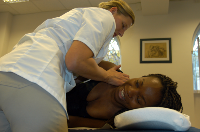 Female osteopath treating female - back and shoulder