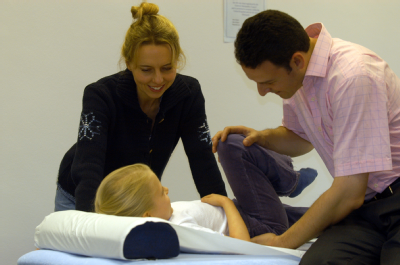 Male osteopath treating female child