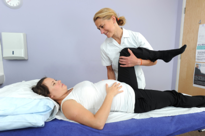 Female osteopath treating pregnant woman