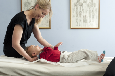 Female osteopath treating toddler 4