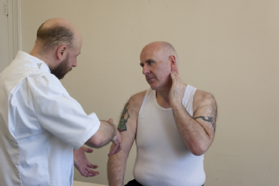 Male osteopath and middle aged man - exercise